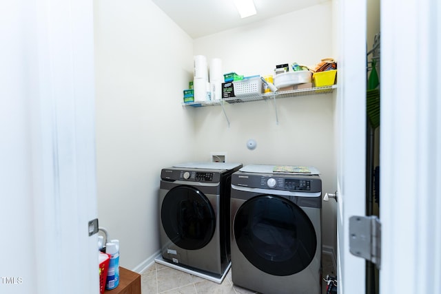 laundry area featuring washer and dryer, baseboards, laundry area, and light tile patterned floors