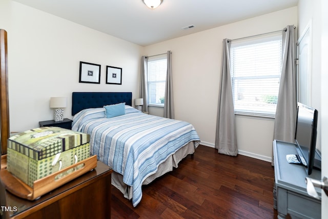 bedroom featuring visible vents, baseboards, and dark wood-style flooring