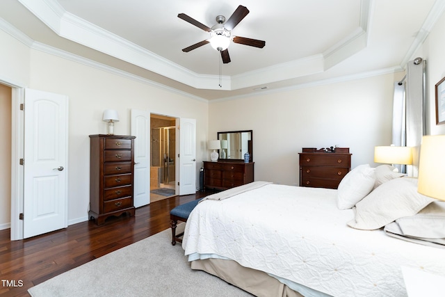 bedroom featuring ceiling fan, a raised ceiling, wood finished floors, and ornamental molding