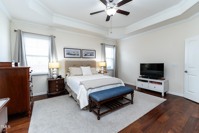 bedroom featuring dark wood-style floors, multiple windows, baseboards, and a tray ceiling