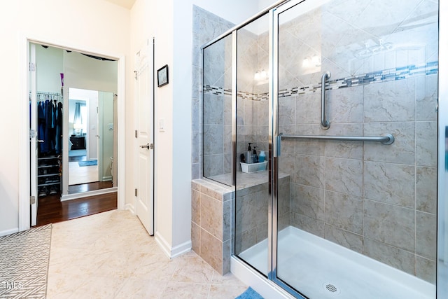 bathroom with a stall shower and baseboards