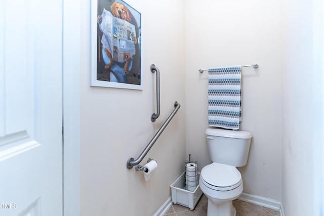 half bath featuring tile patterned floors, toilet, and baseboards