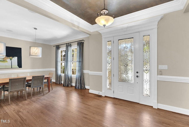 foyer entrance with visible vents, baseboards, wood finished floors, and ornamental molding