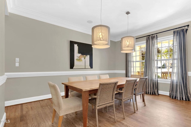 dining space with baseboards, wood finished floors, and crown molding