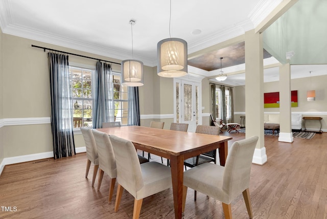 dining room with light wood-type flooring, baseboards, and ornamental molding