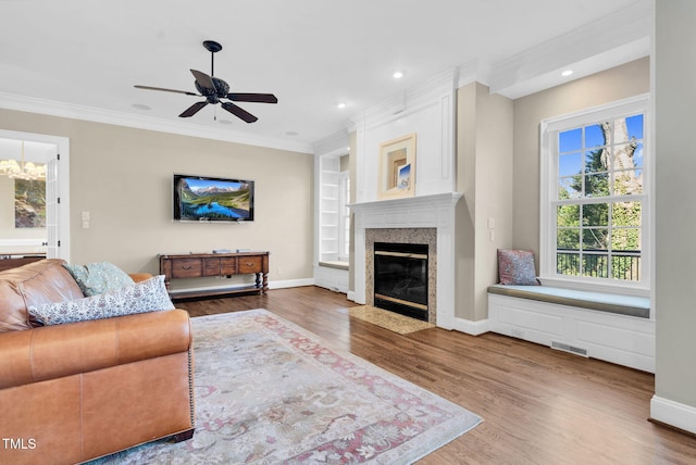 living room with crown molding, wood finished floors, a fireplace, and baseboards