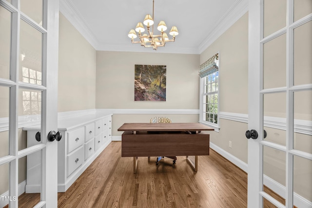 interior space featuring a notable chandelier, crown molding, baseboards, and wood finished floors