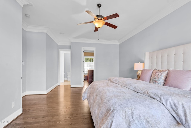 bedroom featuring ornamental molding, ensuite bathroom, baseboards, and wood finished floors