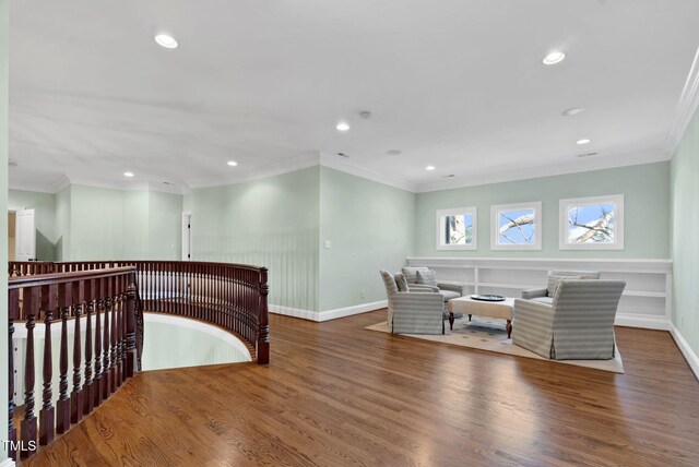 living area with an upstairs landing, wood finished floors, and ornamental molding