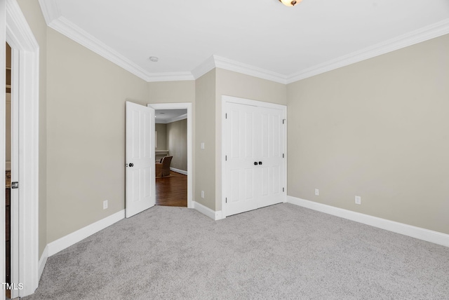 unfurnished bedroom with baseboards, carpet floors, a closet, and crown molding