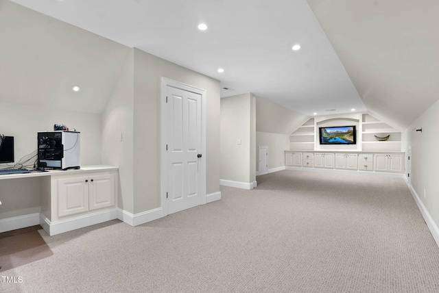 additional living space with built in shelves, baseboards, lofted ceiling, light carpet, and recessed lighting