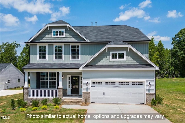 craftsman-style home featuring an attached garage, covered porch, concrete driveway, a front lawn, and brick siding