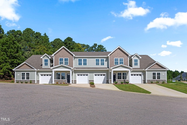 view of front of property with stone siding and driveway