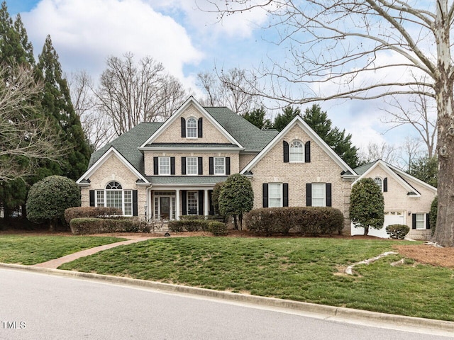 view of front of property with brick siding, a front yard, and a shingled roof