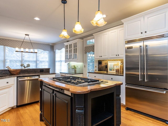 kitchen featuring stainless steel appliances, wooden counters, white cabinets, and light wood-style flooring