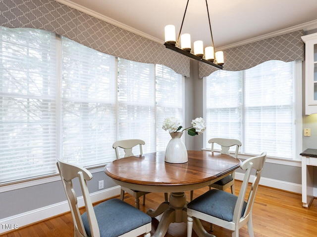 dining space with light wood-style flooring, baseboards, and ornamental molding