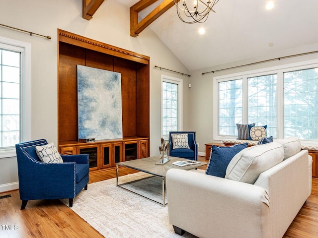 living area with wood finished floors, visible vents, baseboards, an inviting chandelier, and lofted ceiling with beams