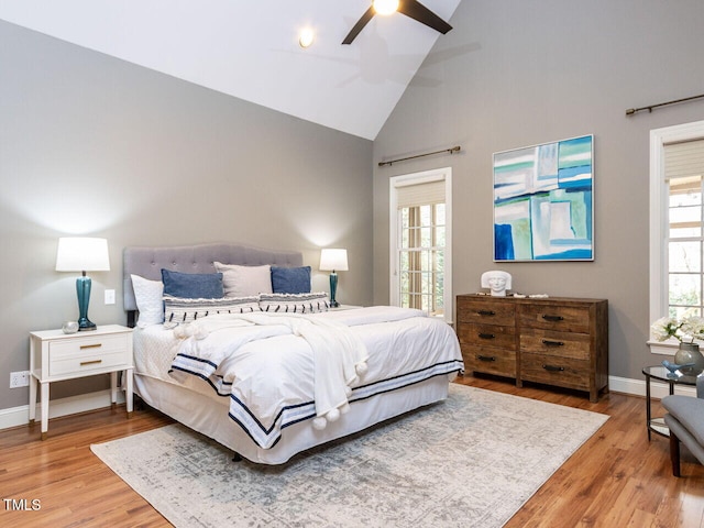 bedroom with high vaulted ceiling, a ceiling fan, baseboards, and wood finished floors