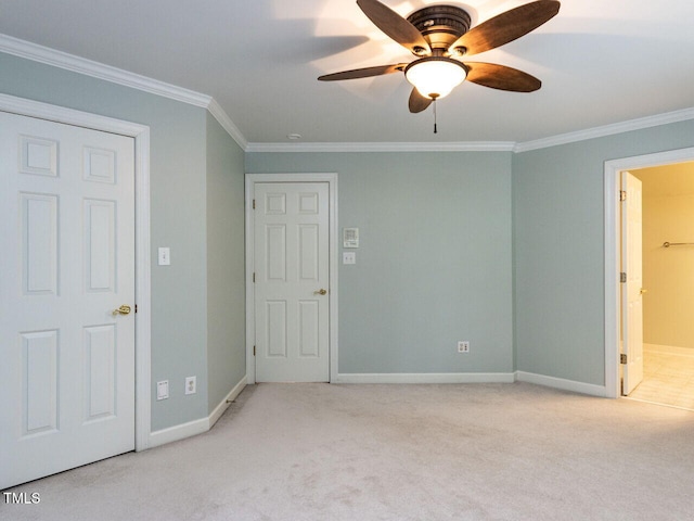 unfurnished bedroom with ornamental molding, connected bathroom, baseboards, and carpet floors