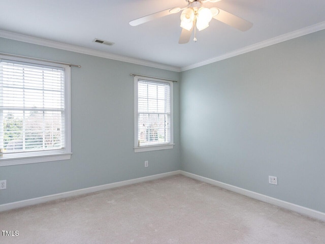 spare room with crown molding, baseboards, visible vents, and light carpet