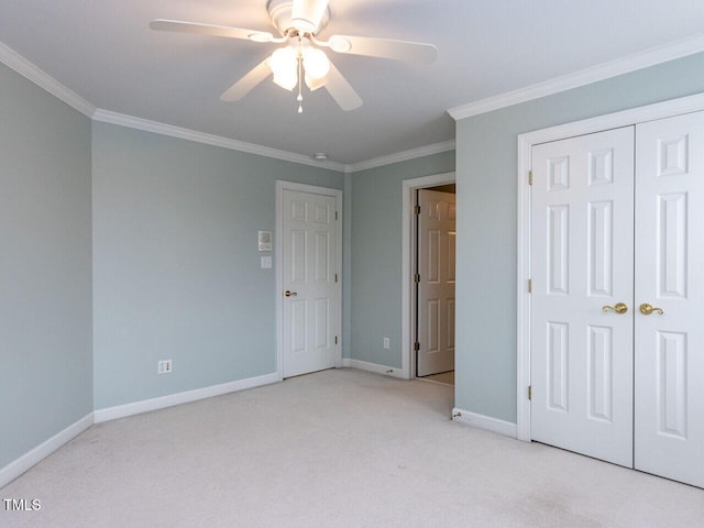 unfurnished bedroom featuring a closet, baseboards, light colored carpet, and ornamental molding