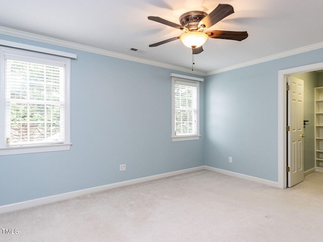 spare room featuring light carpet, a ceiling fan, baseboards, and ornamental molding