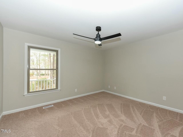 empty room with visible vents, baseboards, ceiling fan, and carpet flooring