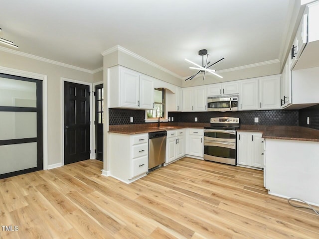 kitchen featuring dark countertops, stainless steel appliances, an inviting chandelier, and a sink