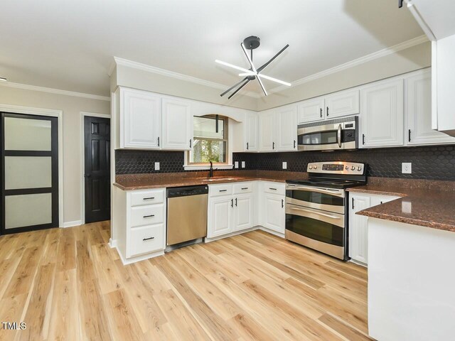 kitchen featuring white cabinetry, light wood-style floors, appliances with stainless steel finishes, and ornamental molding