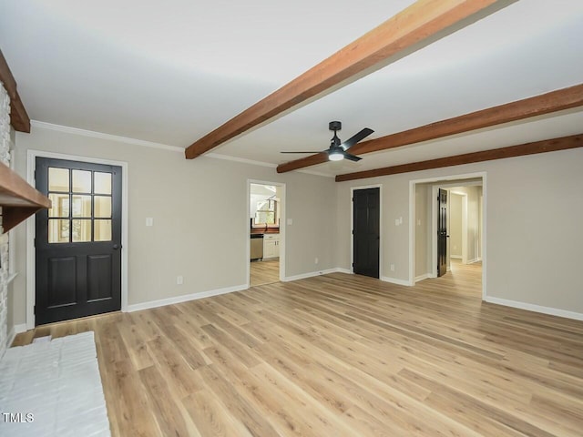 unfurnished living room featuring beamed ceiling, baseboards, and light wood finished floors