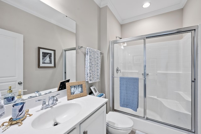 full bathroom featuring vanity, crown molding, toilet, and a shower with shower door