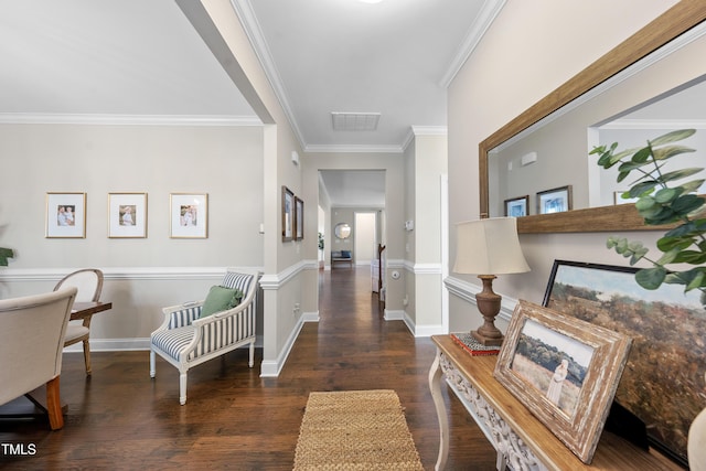 hall featuring visible vents, baseboards, wood finished floors, and crown molding