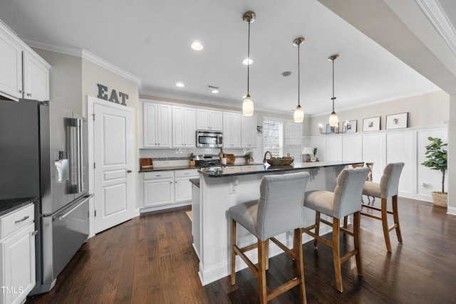 kitchen featuring white cabinetry, dark countertops, appliances with stainless steel finishes, and ornamental molding