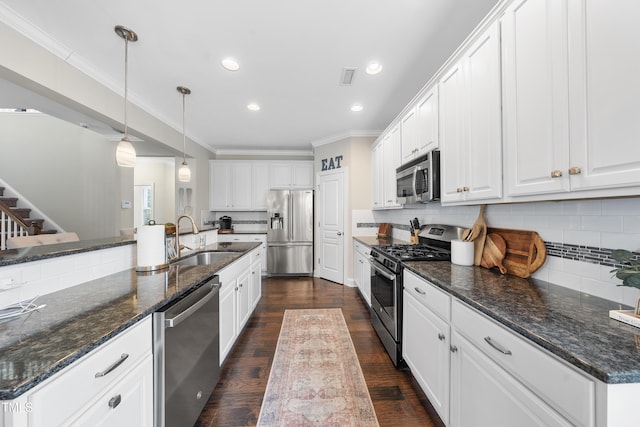 kitchen with visible vents, a sink, stainless steel appliances, white cabinets, and crown molding