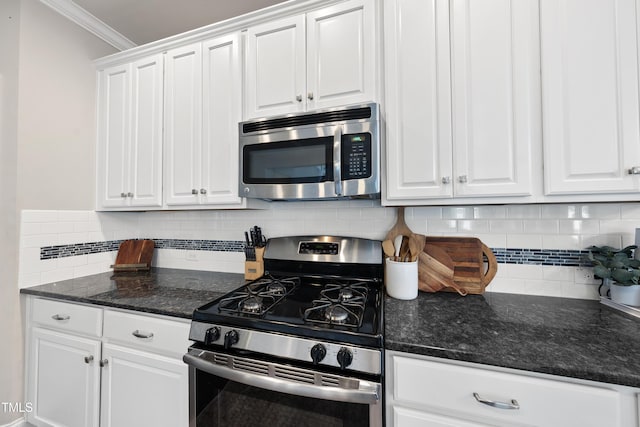 kitchen with white cabinets, backsplash, appliances with stainless steel finishes, and ornamental molding