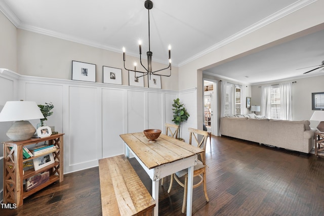 dining space with a decorative wall, crown molding, and dark wood-type flooring