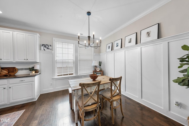 dining area with an inviting chandelier, a decorative wall, dark wood-style flooring, and ornamental molding