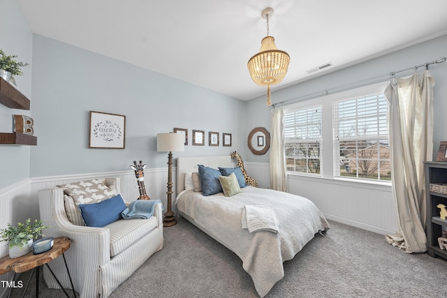 bedroom featuring a chandelier, visible vents, wainscoting, and carpet