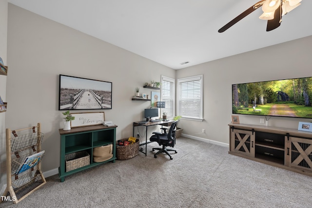 carpeted office with baseboards, visible vents, and ceiling fan