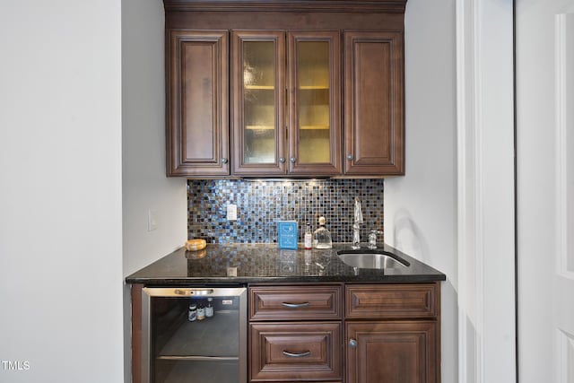 bar with beverage cooler, backsplash, wet bar, and a sink