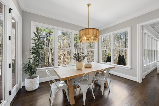 dining space featuring dark wood-type flooring, crown molding, baseboards, and a chandelier