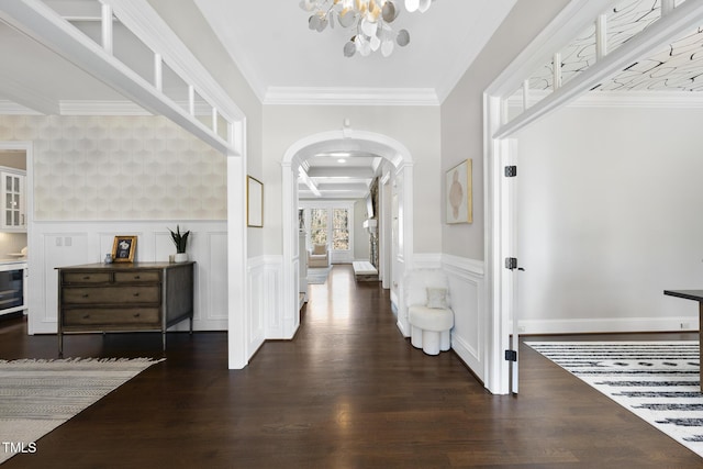 hallway featuring arched walkways, a wainscoted wall, wine cooler, and wood finished floors