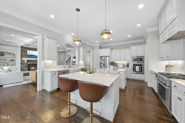 kitchen featuring custom exhaust hood, appliances with stainless steel finishes, dark wood-style flooring, and a center island