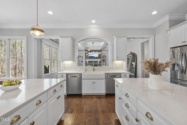 kitchen with dark wood finished floors, light countertops, white cabinets, stainless steel appliances, and a sink