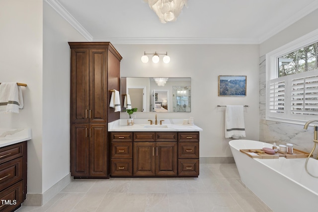 full bath with vanity, baseboards, a freestanding bath, crown molding, and tile patterned floors