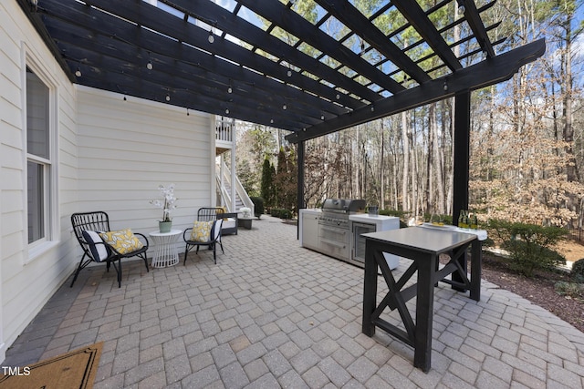 view of patio / terrace with stairs, outdoor dining area, a pergola, and an outdoor kitchen