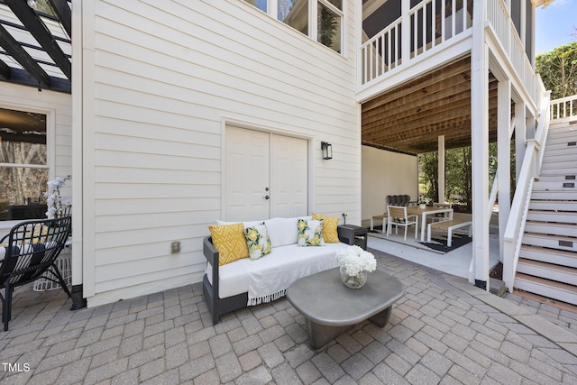 view of patio / terrace featuring outdoor dining space, an outdoor hangout area, a pergola, and stairs