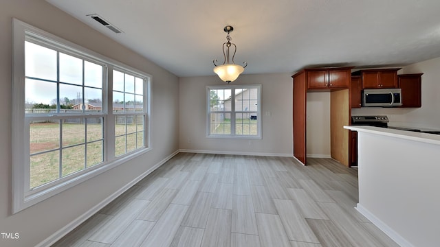 kitchen with visible vents, appliances with stainless steel finishes, light countertops, baseboards, and hanging light fixtures