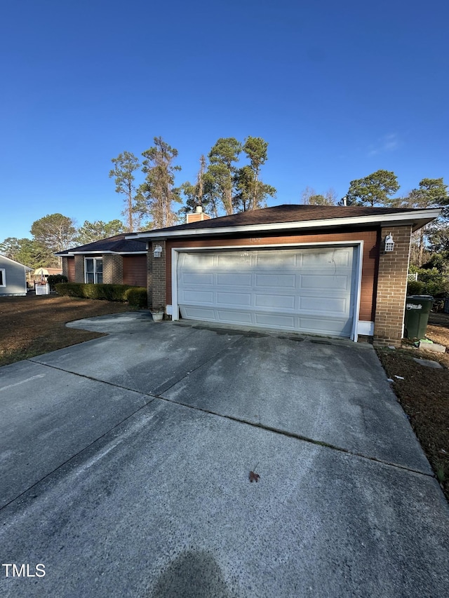 garage featuring concrete driveway