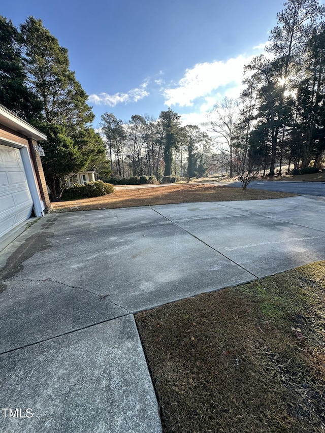 view of yard featuring driveway and a garage